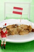 Piece of apple strudel with Austrian flag on plate