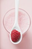 Raspberry shake with spoon & fresh raspberry (overhead view)