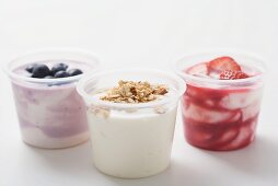 Three yoghurts with berries and cereal