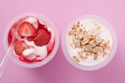 Erdbeerjoghurt und Naturjoghurt mit Cerealien in Bechern