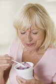 Frau isst Heidelbeerjoghurt