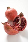 Two pomegranates, one whole and one halved