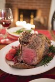 Rib of beef on Christmas table in front of fireplace