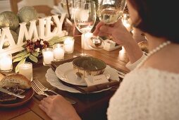 Woman drinking white wine at Christmas meal