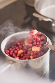 Making cranberry sauce: boiling cranberries and oranges
