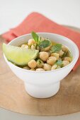 Chick-peas with lime wedge and herbs