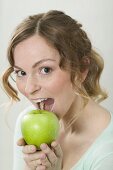 Woman biting into green apple