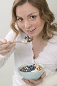 Woman eating muesli with blueberries