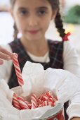 Girl taking candy stick from jar