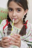 Mädchen trinkt Milch mit Strohhalm