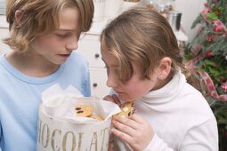 Boy and girl eating chocolate chip cookies