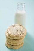 Nut biscuits, in a pile, in front of bottle of milk