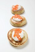 Three blinis with sour cream and caviar