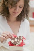 Woman taking checkerboard cookie out of box