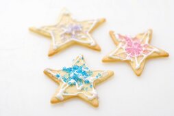 Three star biscuits decorated with coloured sugar