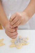 Child decorating Christmas biscuit using piping bag