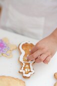 Child decorating Christmas biscuit with silver balls