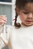 Small girl holding Christmas bell