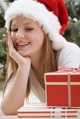 Woman in Father Christmas hat looking at Christmas parcel