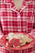 Woman holding plate of gingerbread men