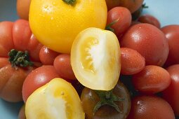 Various types of tomatoes with drops of water