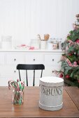 Candy canes & cookie tin in kitchen with Christmas decorations