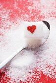 Sugar cube with red heart on spoon
