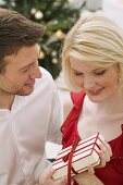 Man giving Christmas gift to woman