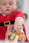 Baby nascht Süssigkeiten aus Vorratsglas