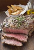 Sirloin Steak, angeschnitten, Potato Wedges im Hintergrund