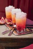 Three fruity drinks with orange and pomegranate