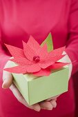 Woman holding Christmas parcel with poinsettia