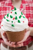 Frau hält Cupcake zu Weihnachten