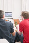 Two football fans watching football match on TV