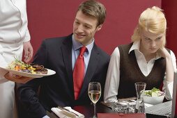 Waiter serving lunch to business people