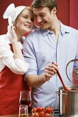 Couple cooking pasta with tomatoes