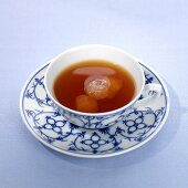 Tea with sugar crystals in cup and saucer