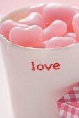Pink heart-shaped sweets in beaker for Valentine's Day