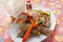 Stir-fried beef, soy sauce, rice in take-away container