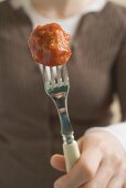 Woman holding meatball on fork