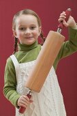 Small girl holding rolling pin