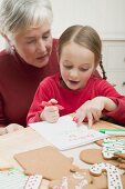 Small girl with grandmother writing Christmas letter