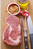 Beef steak, spice mixture, cutlery and oil