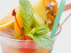 Cocktail with exotic fruit skewer and mint (close-up)