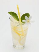 Ein Glas Zitronenlimonade mit Zitronenblüte und Strohhalm