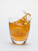 Iced tea splashing out of a glass