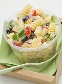 Pasta and vegetable salad in plastic container