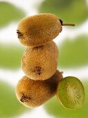 Three whole baby kiwis (stacked) beside half a baby kiwi