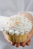 Hands holding cupcake