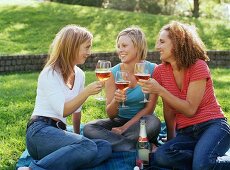 Three friends clinking glasses of rosé sparkling wine